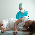 Médecin réalisant une infiltration lombaire au niveau L5-S1 sous guidage médical.